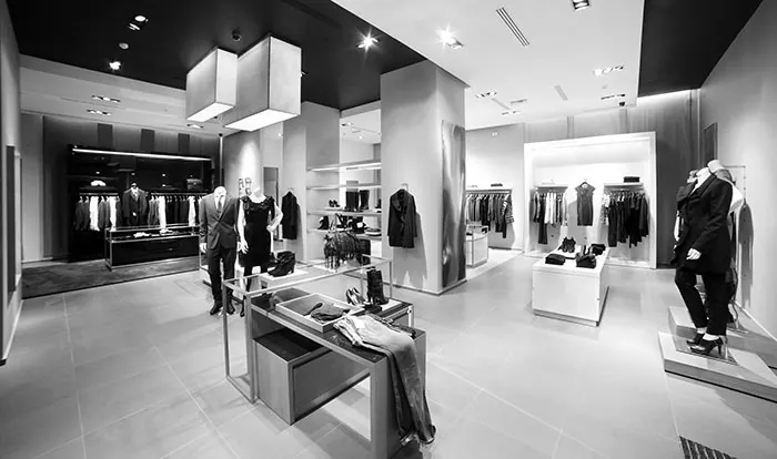 Clothing boutique interior with garment racks, mannequins and display tables
