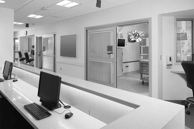 Medical office reception desk with a computer and exam room beyond