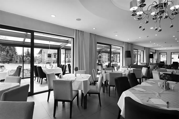 Restaurant dining room with set tables and a crystal chandelier